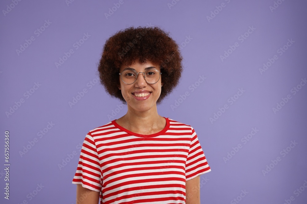 Portrait of happy young woman in eyeglasses on purple background. Space for text