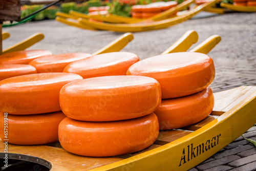 whole gouda cheese on wooden barrows at alkmaar cheese market photo