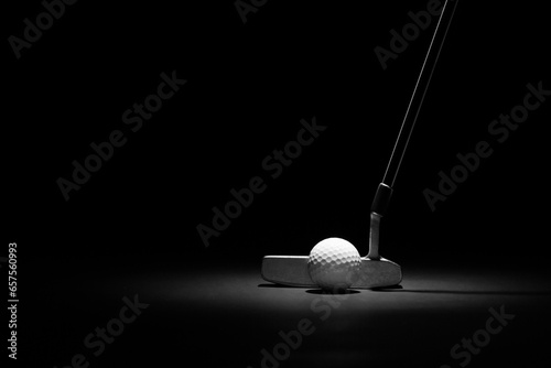 Golf Putter and Ball Spotlit on a Black Background with Copy Space