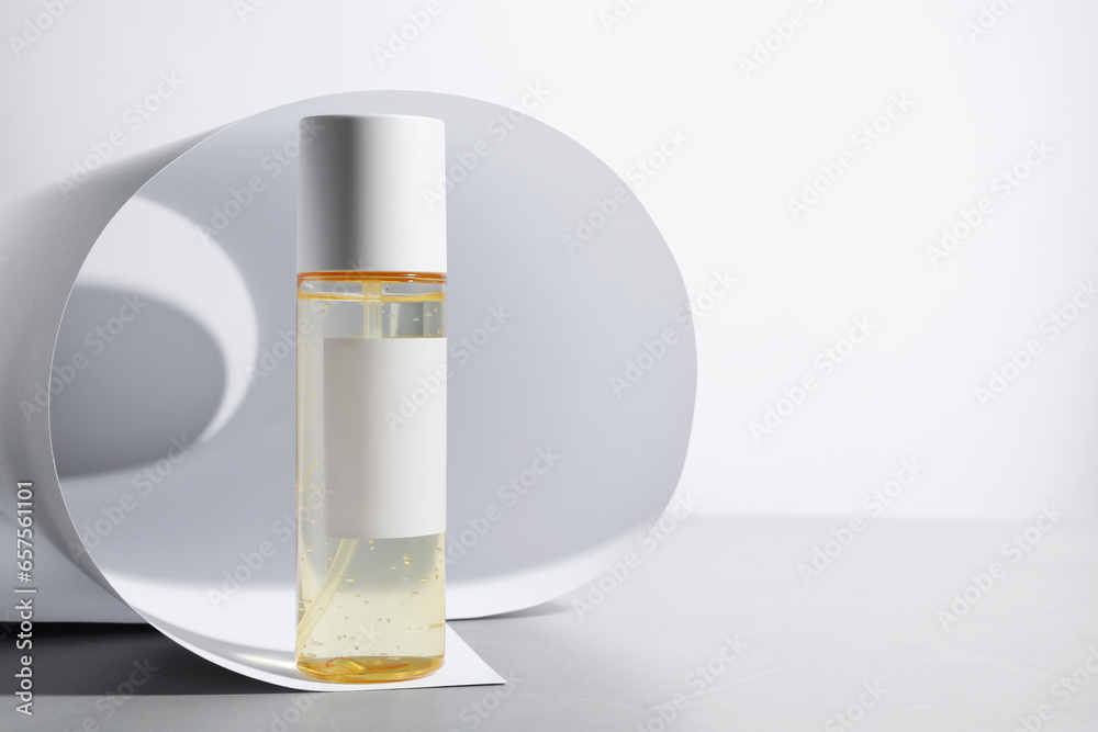Bottle of cosmetic product on light grey table. Space for text Bottle of cosmetic product on light grey table. Space for text