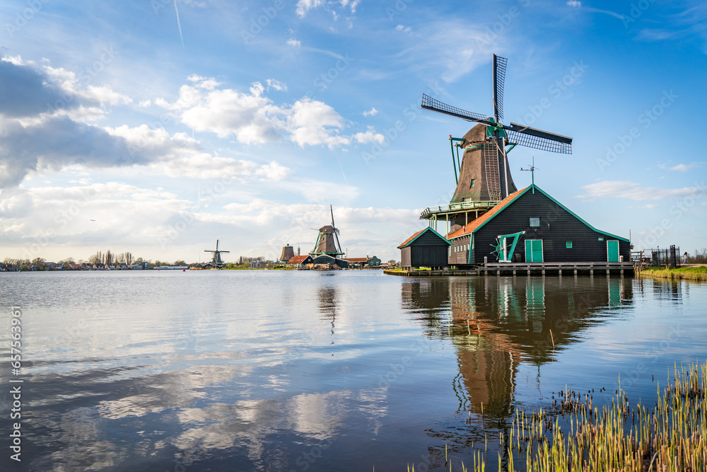 traditional dutch windmills reflecting in lake at zaanse schans