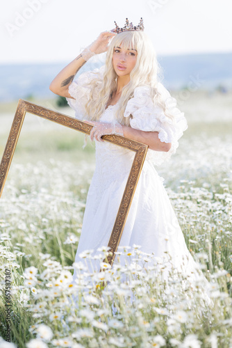 Girl in a white dress and a crown with a bouquet in a chamomile field at sunset, view from the back, a princess on a walk photo