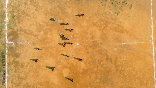4K Cinematic sport aerial drone footage of children playing on a footbal field in the mountain village of Doi Pui next to Chiang Mai, Thailand on a sunny day