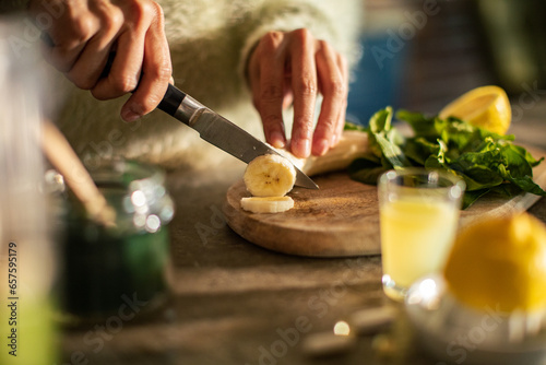 Close-up of a young woman preparing an organic smoothie in the kitchen at home