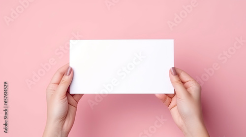 Female hands with blank business card or discount card on Flat color background with copy space