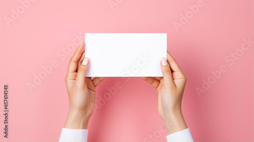 Female hands with blank business card or discount card on Flat color background with copy space