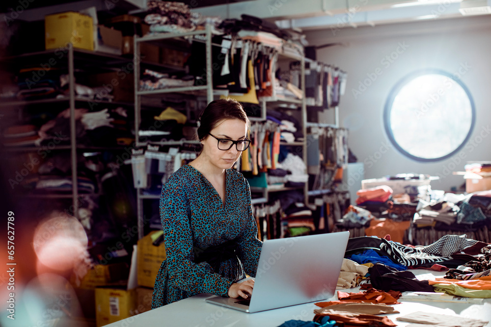 Young woman using the laptop while working in a textile manufacturing company