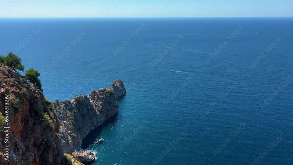 The blue waves of the Mediterranean Sea crash against the rocky shores. The blue waves of the Mediterranean Sea crash against the rocky shores.