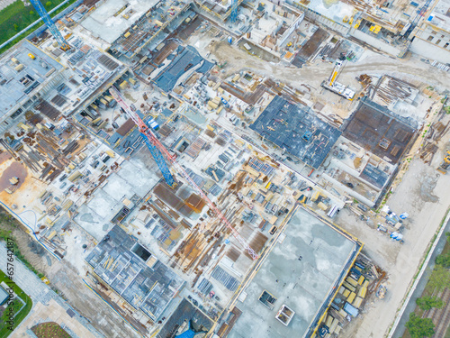 Construction site with cranes. Construction workers are building. Aerial view of construction site of residential area buildings with cranes