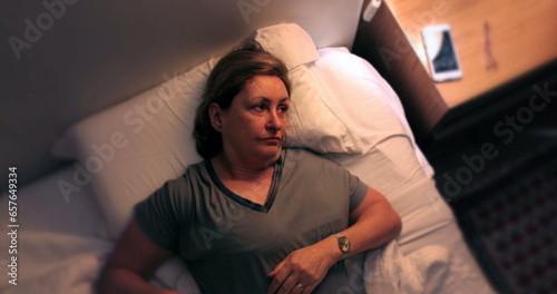 Konstfotografi Tired Woman waking up in the middle of the night unable to sleep, turns on night