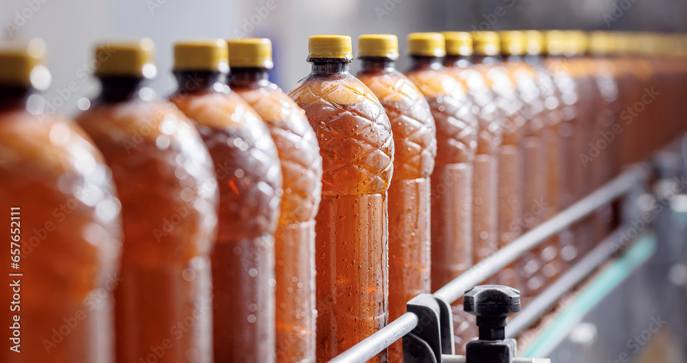 Concept banner modern production line brewery industry. Conveyor with brown plastic beer bottles with drink alcohol Concept banner modern production line brewery industry. Conveyor with brown plastic beer bottles with drink alcohol