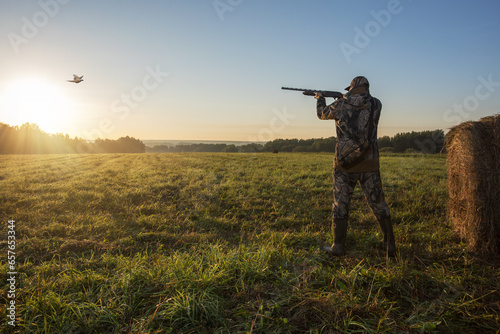 Hunter aiming with rifle on pheasant. Hunter man.