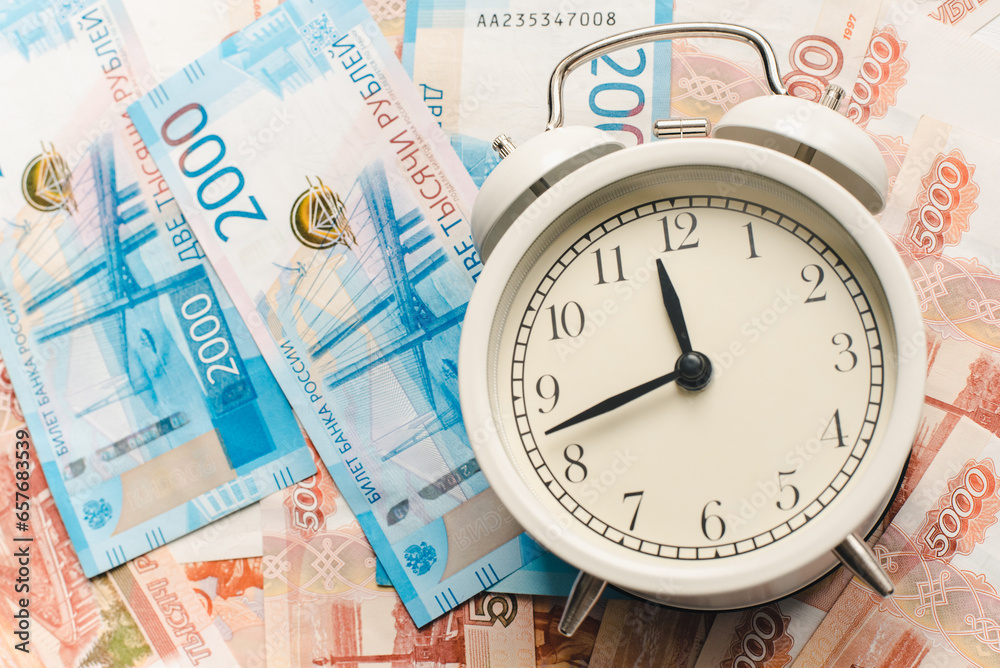 Time to pay taxes. Alarm clock and Russian banknotes. Time is money. Time to pay taxes. Alarm clock and Russian banknotes. Time is money.