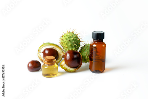 Autumn horse chestnut with peel, bottles with oil and chestnut extract on a white background