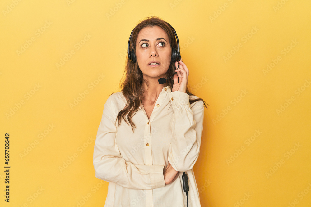 Middle aged woman customer service rep with headset on yellow Middle aged woman customer service rep with headset on yellow