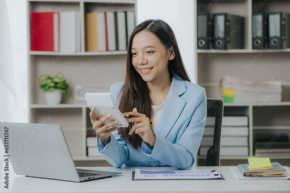 Happy Asian businesswoman working in modern office using laptop computer Happy Asian businesswoman working in modern office using laptop computer