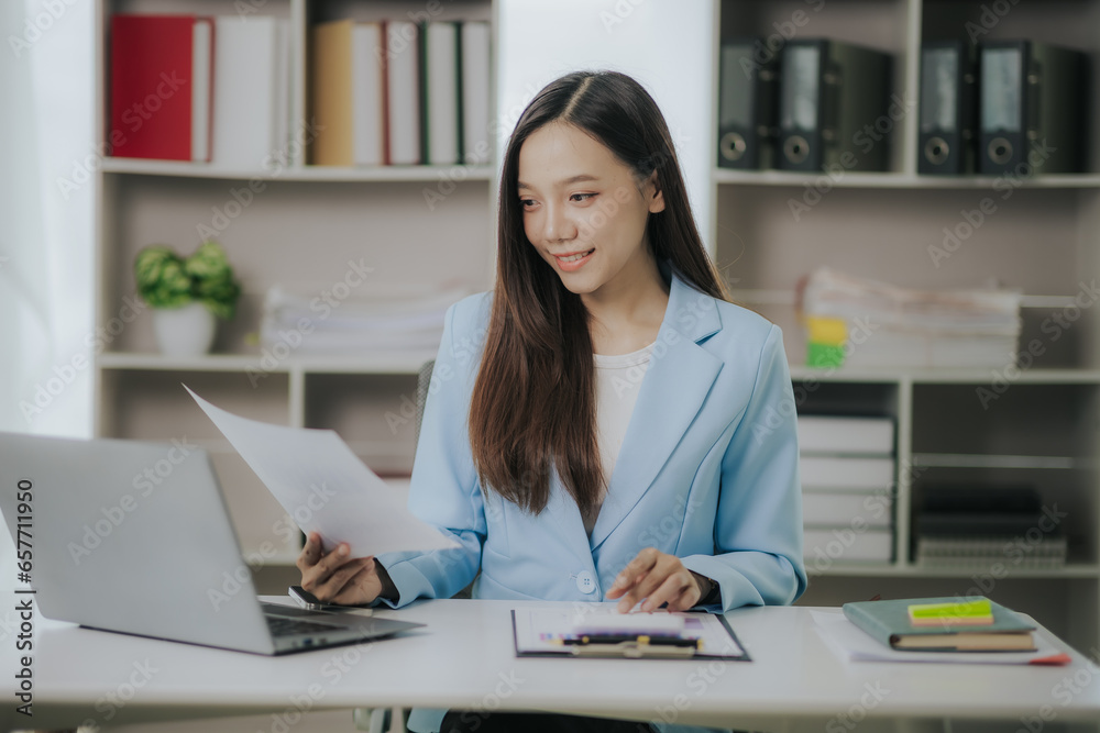 Happy Asian businesswoman working in modern office using laptop computer Happy Asian businesswoman working in modern office using laptop computer