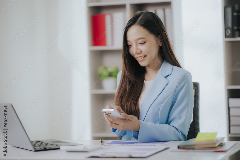 Happy Asian businesswoman working in modern office using laptop computer Happy Asian businesswoman working in modern office using laptop computer