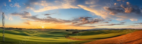 Panoramic view captures the breathtaking landscape of rolling hills bathed in the warm glow of a setting sun. The image evokes a sense of peace, beauty, and the grandeur of nature.