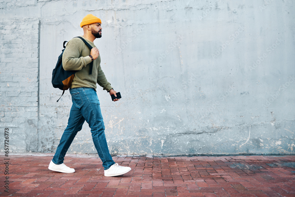 Walking, student and travel with man on wall, mockup and space in urban, campus or street in town. University, person and commute on path, road or journey to college in city with phone or backpack - obrazy, fototapety, plakaty 