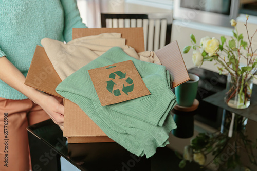 Quadro su tela Woman packing box with used wardrobe and card with circular economy logo