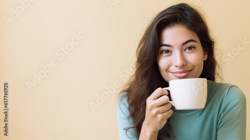 jeune femme brune cheveux long en train de boire un café, studio photo, arrière plan neutre, espace pour texte