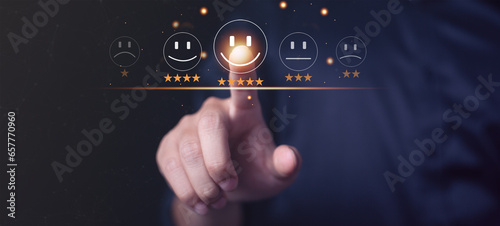 Businessman pressing smiley face emoticon on virtual touch screen. Customer service evaluation concept or Success ranking star on marketing opinion result is excellent.