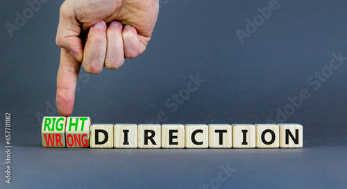 Right or wrong direction symbol. Concept words Right direction Wrong direction on wooden blocks. Beautiful grey background. Businessman hand. Business right or wrong direction concept. Copy space.