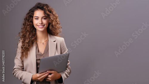Smiling curly brunette businesswoman holding laptop computer