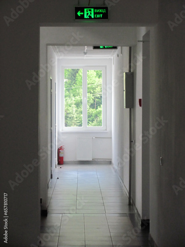 In the corridor at the factory  there are signs for the exit from the production premises