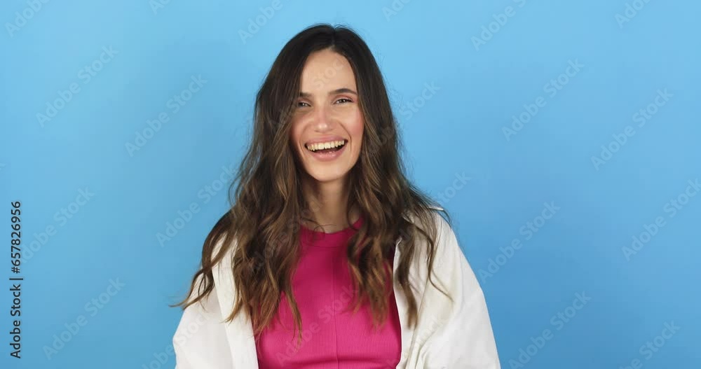 Yes sir. Young woman looking at camera with salute and ready to do your order. Positive facial emotion. Brunette woman in white shirt and pink top saluting holding hand near head on blue background. Yes sir. Young woman looking at camera with salute and ready to do your order. Positive facial emotion. Brunette woman in white shirt and pink top saluting holding hand near head on blue background.