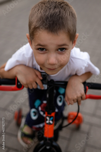A boy on a bicycle rides down the street. Ecology. Children's cycling
