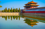 View of the Forbidden City with the reflection on the moat on a sunny day in Beijing, China.