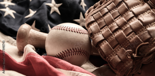 A baseball glove, bat and ball on American flag. The national pastime photo