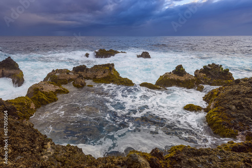 Atlantic Ocean and lava rock coast at dawn at Charco del Viento in La Guancha on Tenerife in the Canary Islands, Spain photo