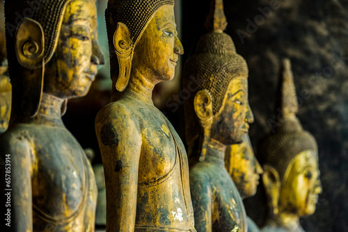 Row of standing Buddha images at Wat Visoun, commonly known as That Makmo; Luang Prabang, Laos photo