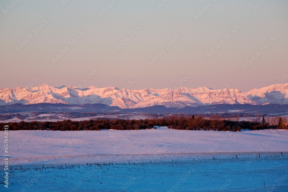 Sunrise Over Canadian Rockies And Snowy Field; Cochrane, Alberta, Canada