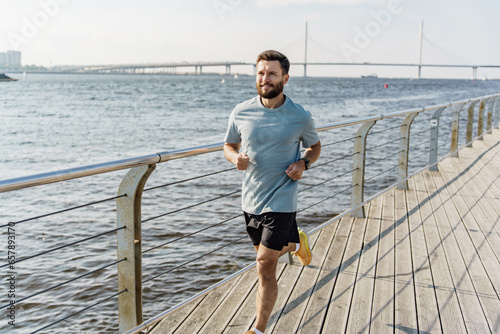 Fototapeta Naklejka Na Ścianę i Meble -  Jogging male runner. A healthy person trains alone in fitness clothes. Physical activity cardio lifting training for the body. Sports running shoes.