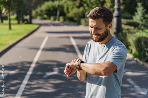 Uses a fitness tracker and a mobile app for running. The instructor is a male sports runner interval training. Mental and psychological health during fitness exercises. photo
