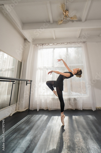 A beautiful Asian woman is dancing at the barre. Ballet dancer.