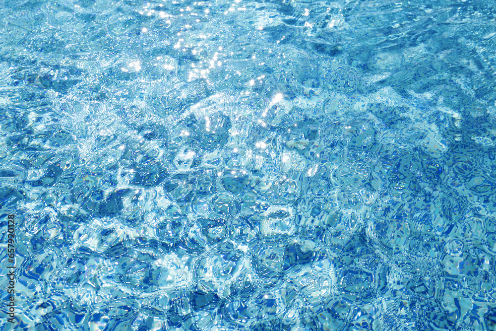 Water ripples on blue tiled swimming pool background. View from above. vacation and summer concept. 