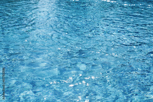 Water ripples on blue tiled swimming pool background. View from above. vacation and summer concept. 