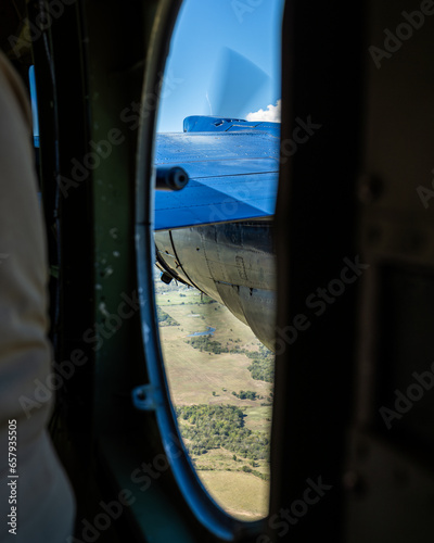 view of engine nacelle and propellor from side window of vintage bomber