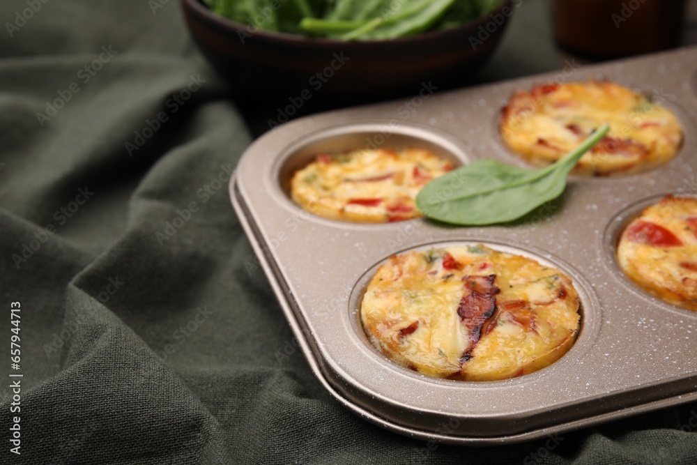 Freshly baked bacon and egg muffins with cheese in tin on table, closeup. Space for text Freshly baked bacon and egg muffins with cheese in tin on table, closeup. Space for text
