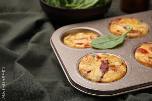 Freshly baked bacon and egg muffins with cheese in tin on table, closeup. Space for text