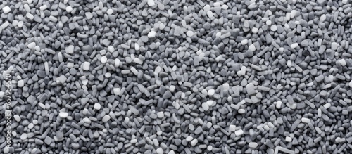 Grey chemical granules for industrial plastic production specifically made of polypropylene resin masterbatch shown in a close up background texture