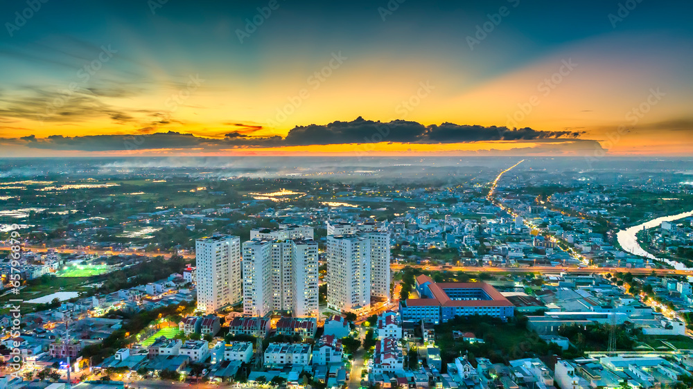 Aerial view of Saigon cityscape at evening with sunset sky in Southern Vietnam. Urban development texture, transport infrastructure and green parks - obrazy, fototapety, plakaty 