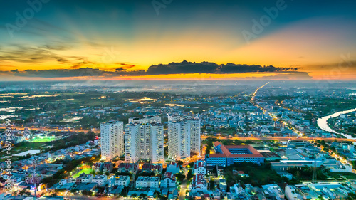 Aerial view of Saigon cityscape at evening with sunset sky in Southern Vietnam. Urban development texture, transport infrastructure and green parks © huythoai