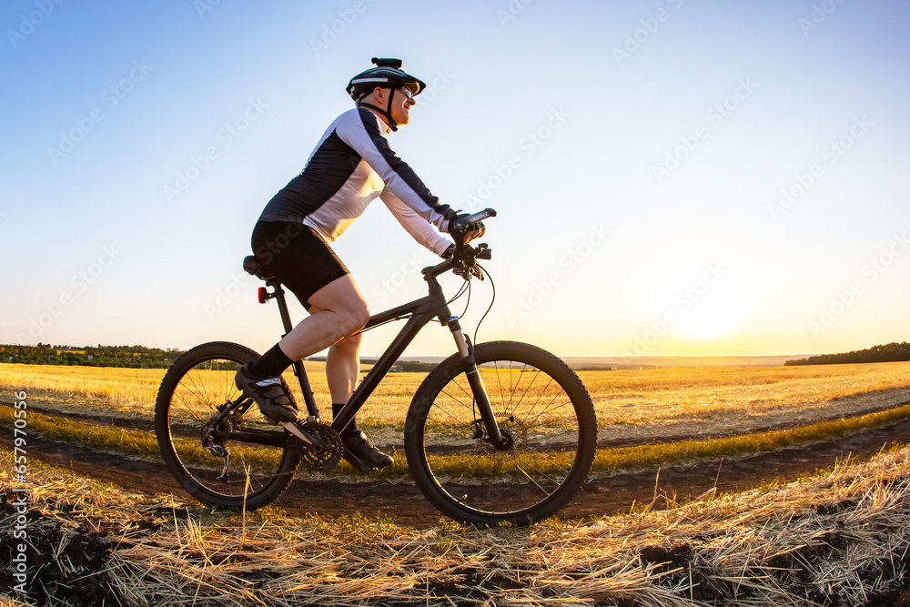 Obraz premium man cyclist rides a bike on a road in nature. sports, cycling and health hobbies