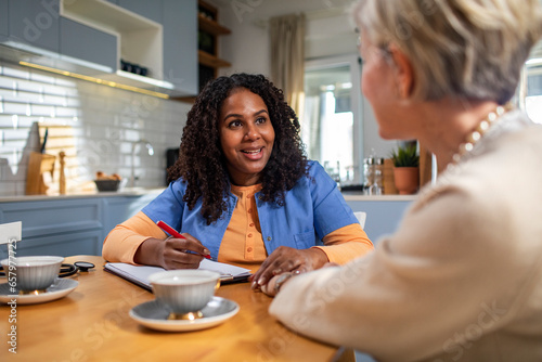 Senior woman consulting her caregiver in the kitchen at home